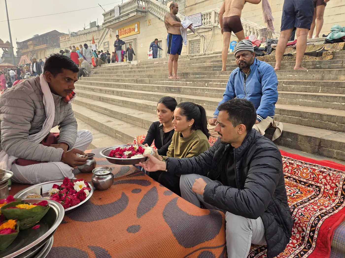 Purohit performing pooja with flowers for devotees